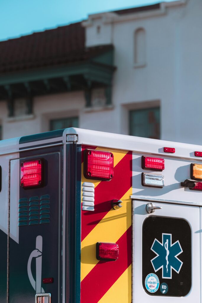Close-up of an ambulance with emergency lights on in a city environment, conveying urgency and response.