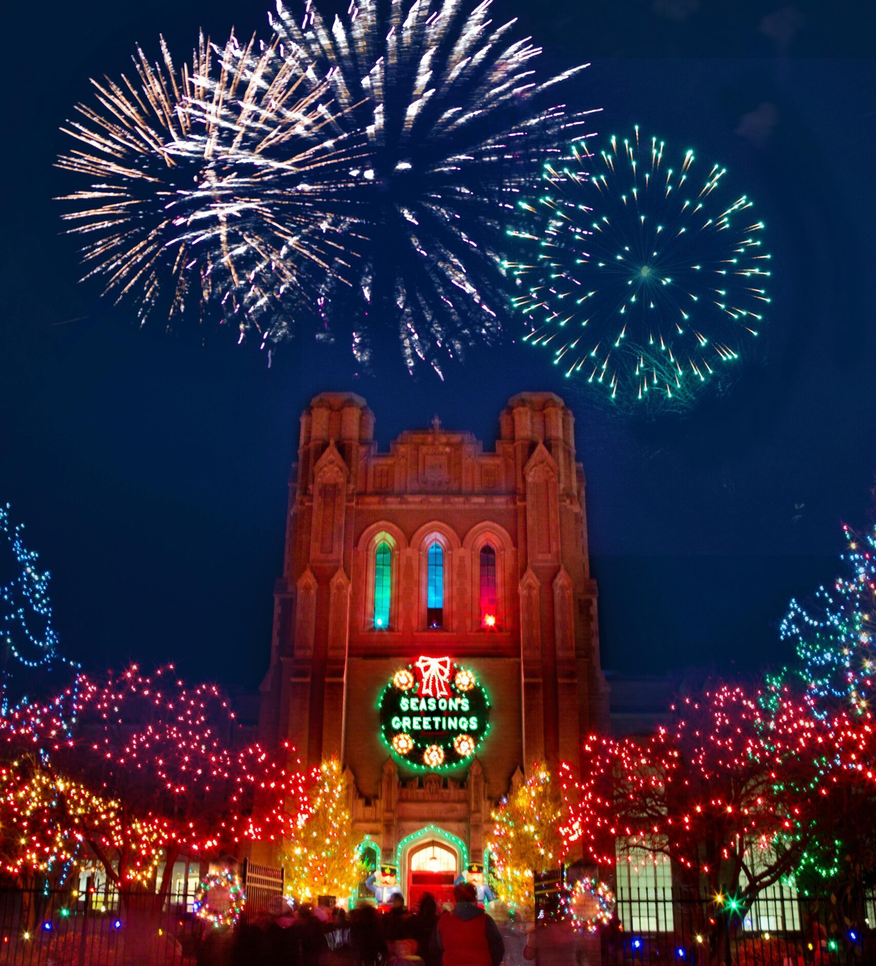 Capture of festive fireworks and illuminated Gothic-style building during a holiday celebration in Saginaw, Michigan.