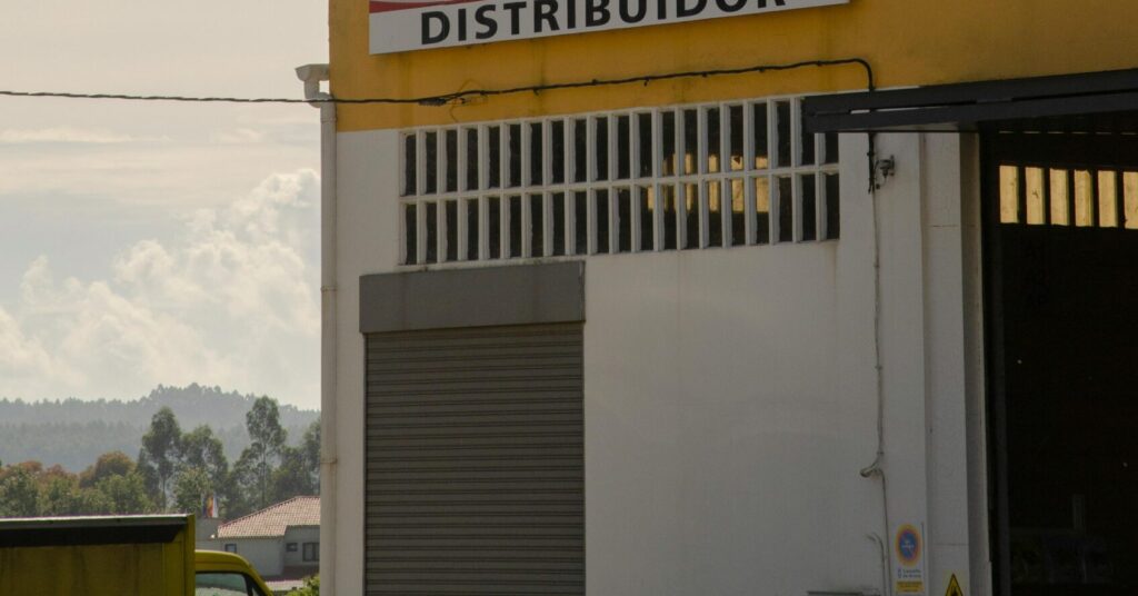 Outdoor view of Coca-Cola distributor sign on a building under a clear sky.