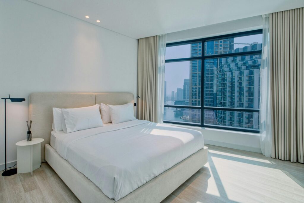 Elegant modern bedroom with a stunning view of city skyscrapers.